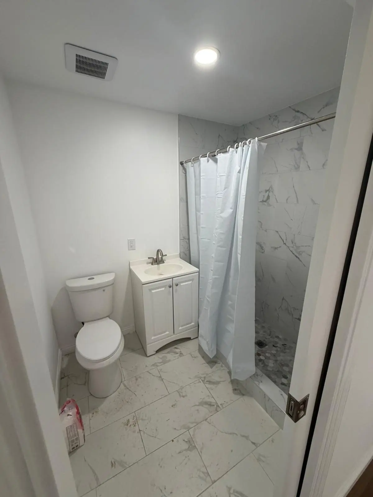 Finished ADU bathroom with marble-look tile shower