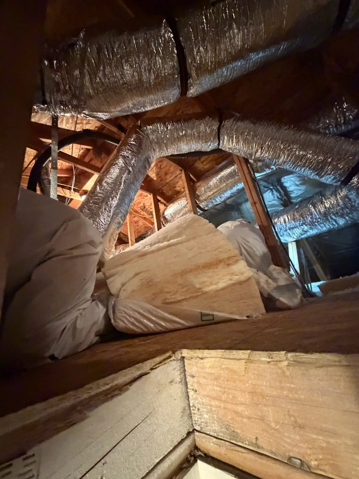 Installer placing insulation batts in an attic