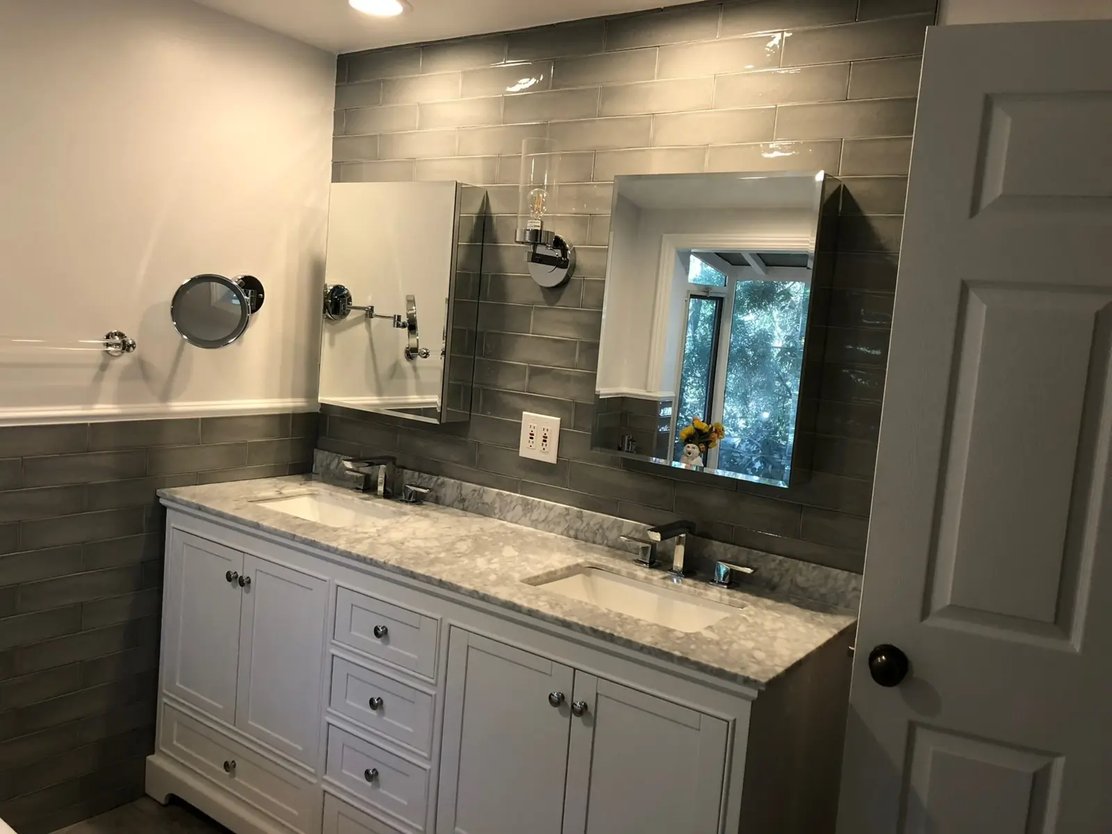 Double vanity with marble top and grey subway tile wainscot