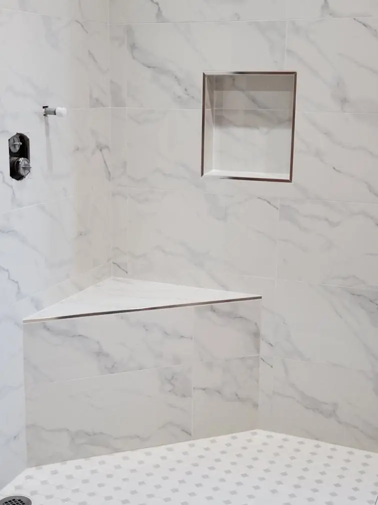 Marble-look shower with corner bench and recessed niche