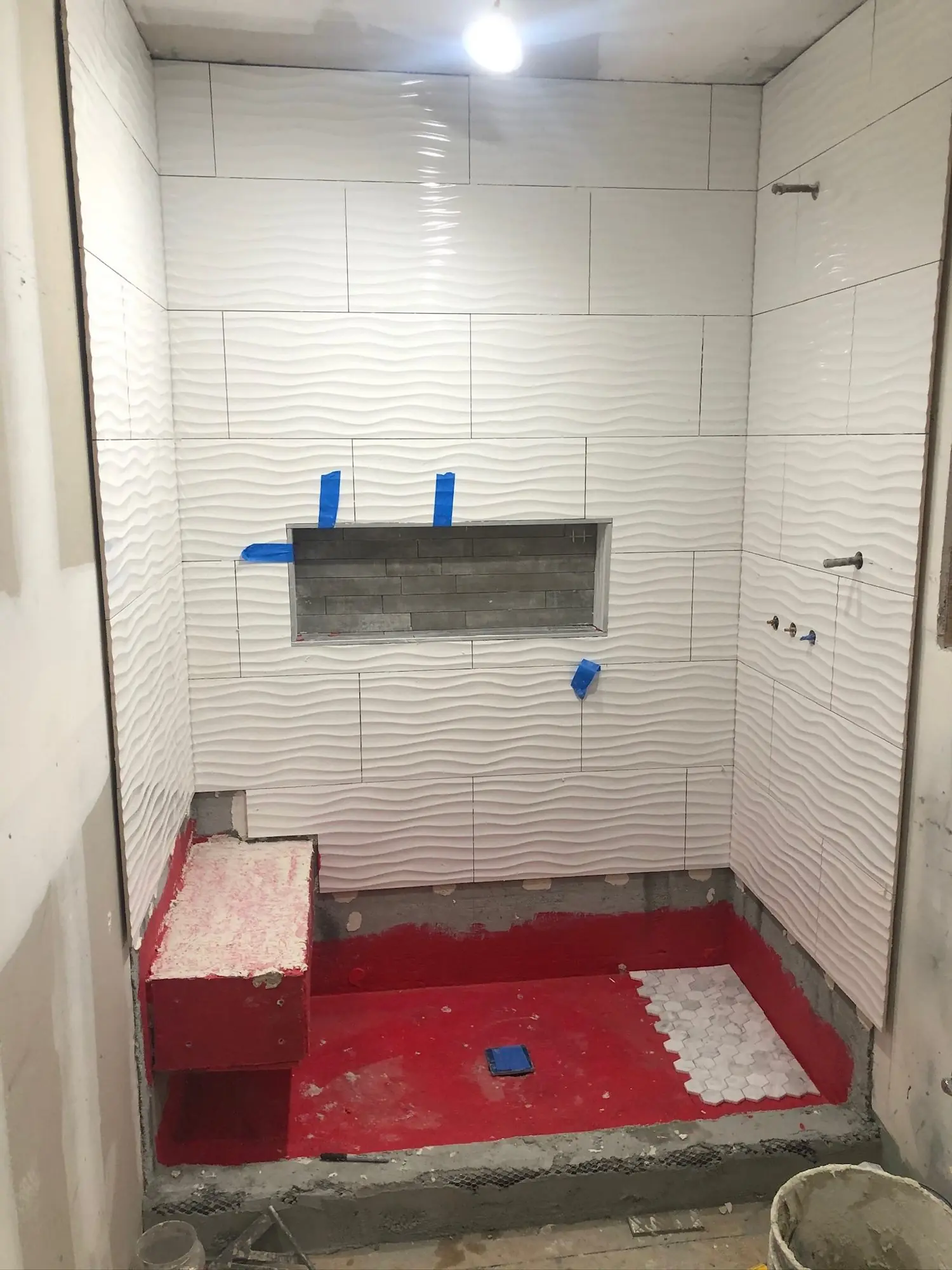 Shower pan waterproofing and tile going in during a bathroom remodel