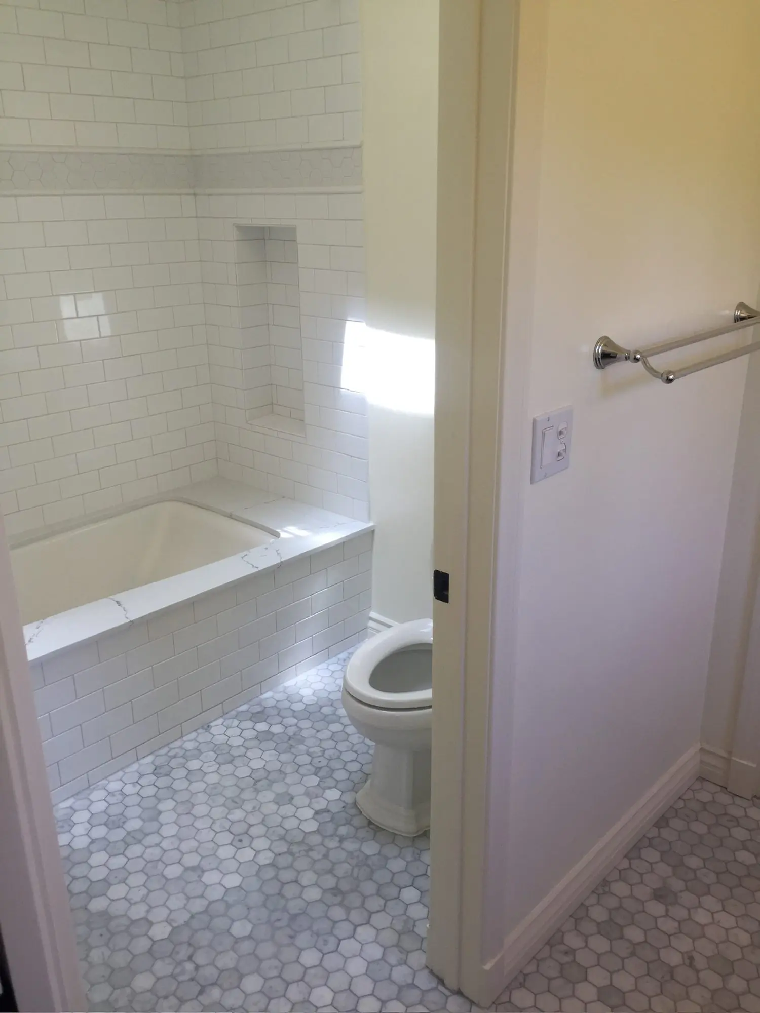 Subway tile tub surround with marble hex floor