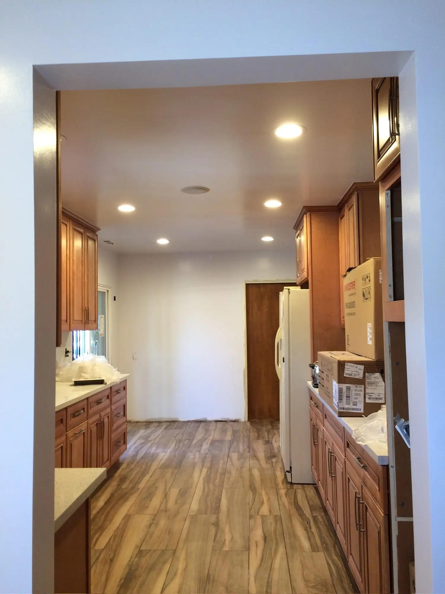 Galley kitchen with new cabinets and recessed lighting