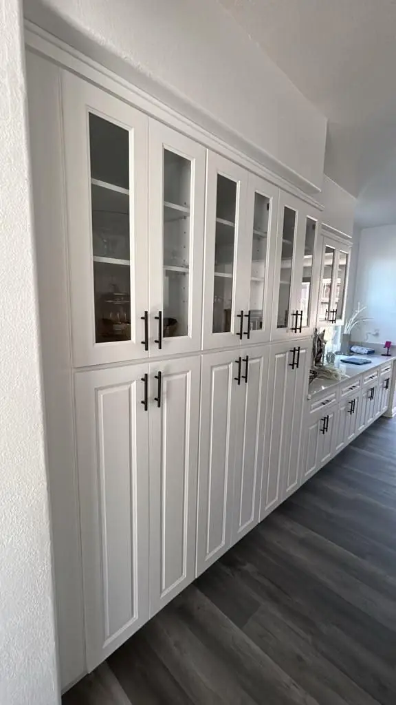Full-height pantry wall with glass-front upper cabinets