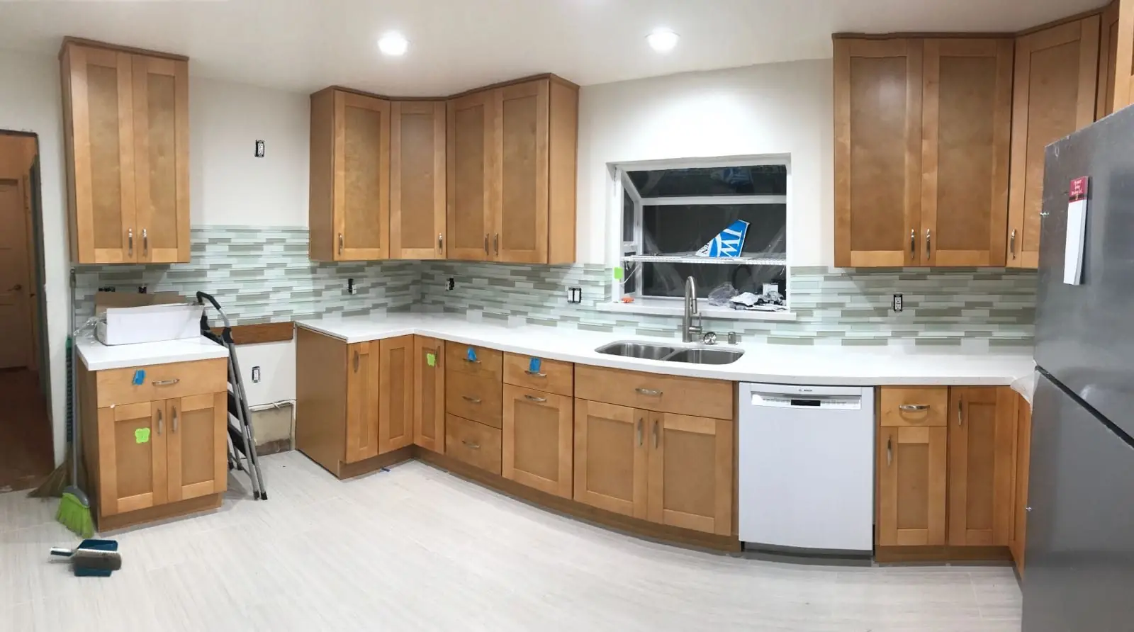 Maple shaker kitchen with white quartz and glass tile backsplash