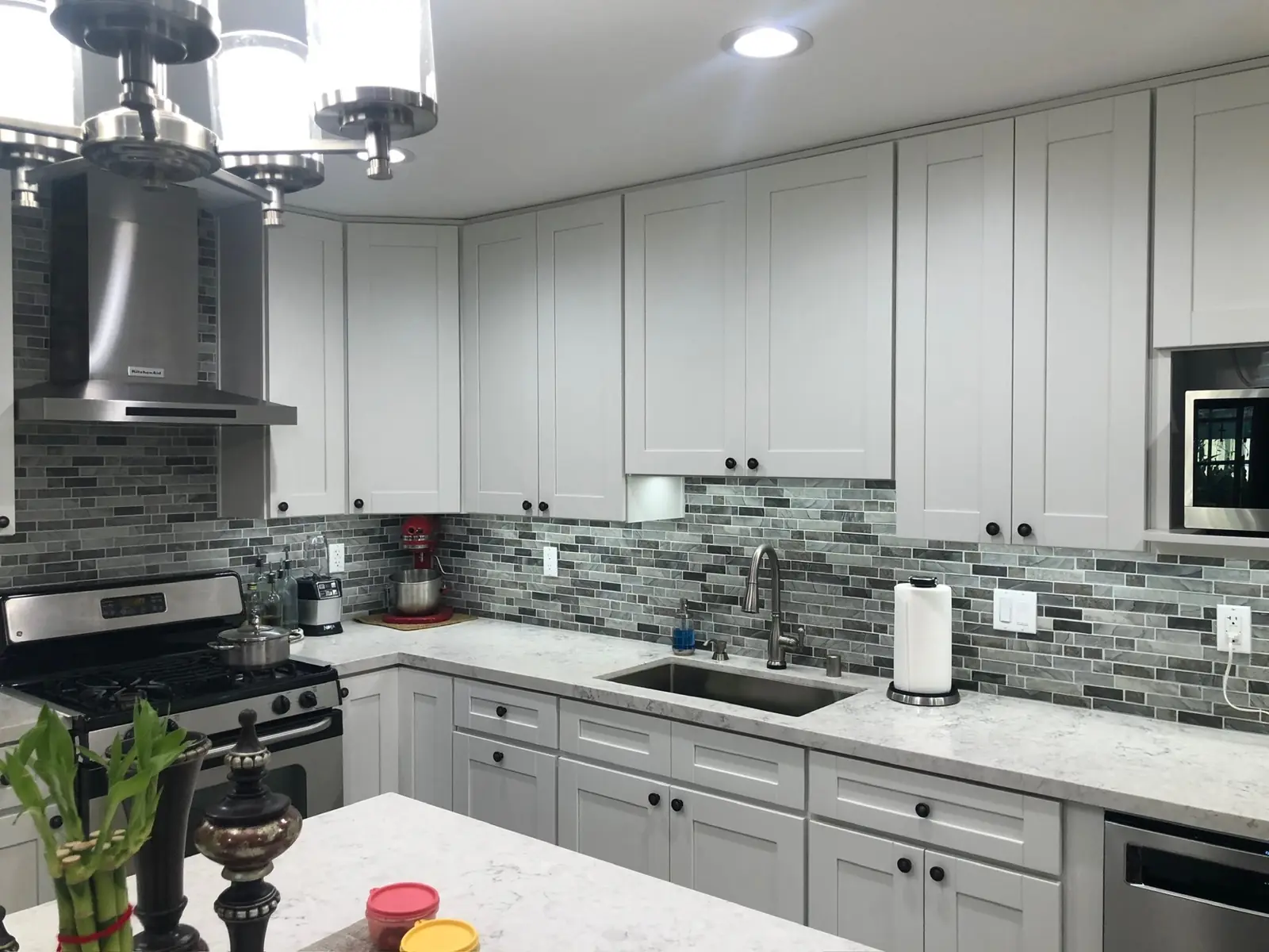 White shaker kitchen with stone mosaic backsplash