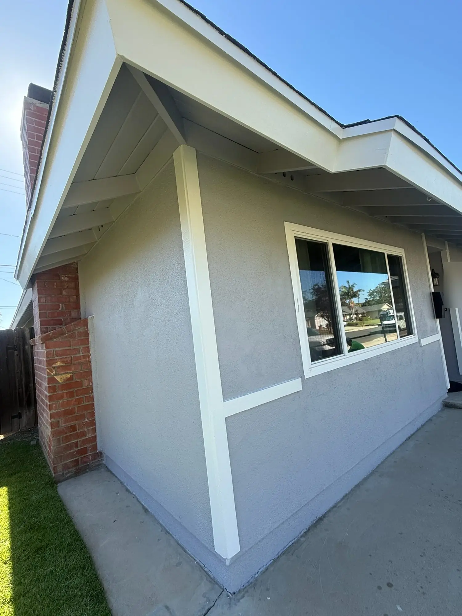 Freshly painted grey stucco with crisp white trim and fascia