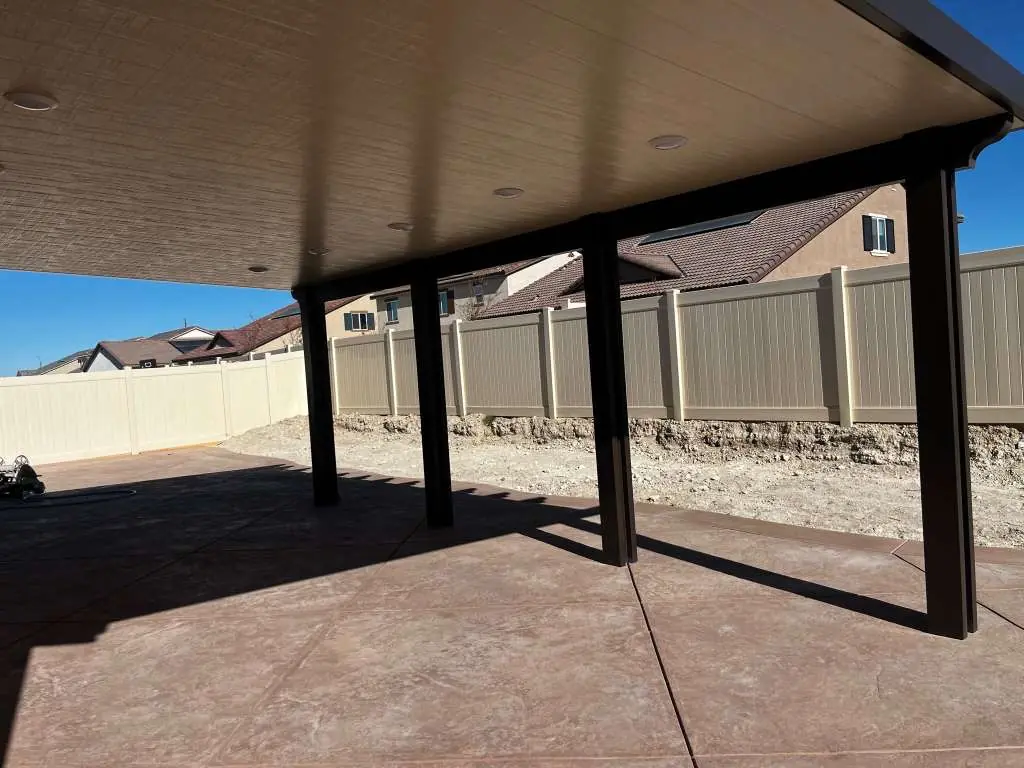 Solid patio cover with dark posts and recessed lights