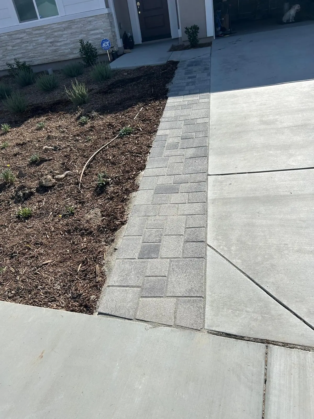 Paver border extending a front driveway