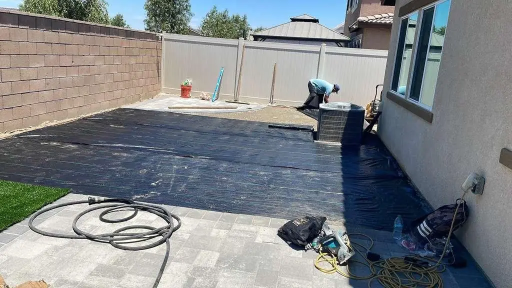 Weed barrier laid before turf next to new pavers